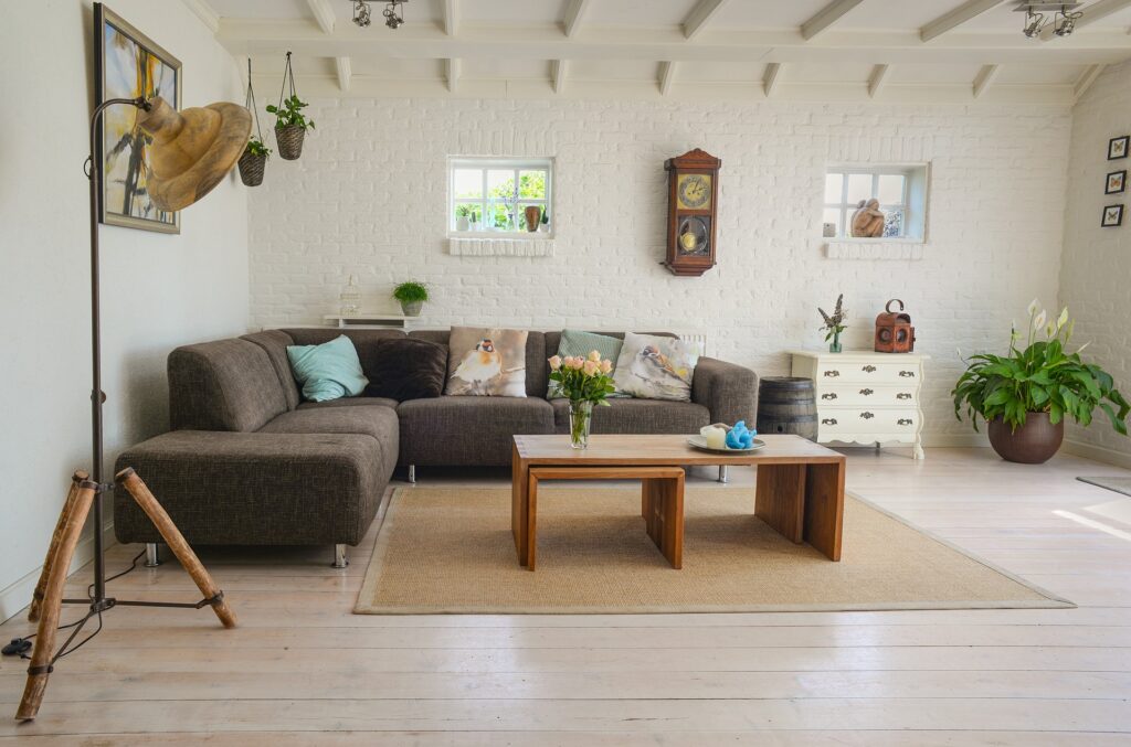 A cosy living room with a sectional sofa, rustic coffee table and vintage accents, designed by Carlo Picasso Decorators.