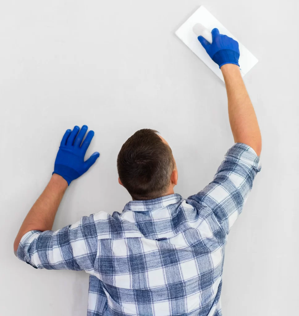 Sponge cleaning wallpaper paste residue from a stripped wall before painting or re-papering
